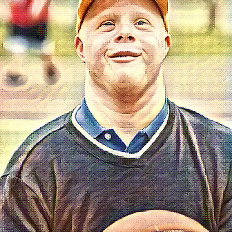 A man smiling holding a ball in hand